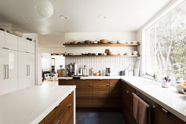 white kitchen dark floors with wood lower cabinets and open shelving