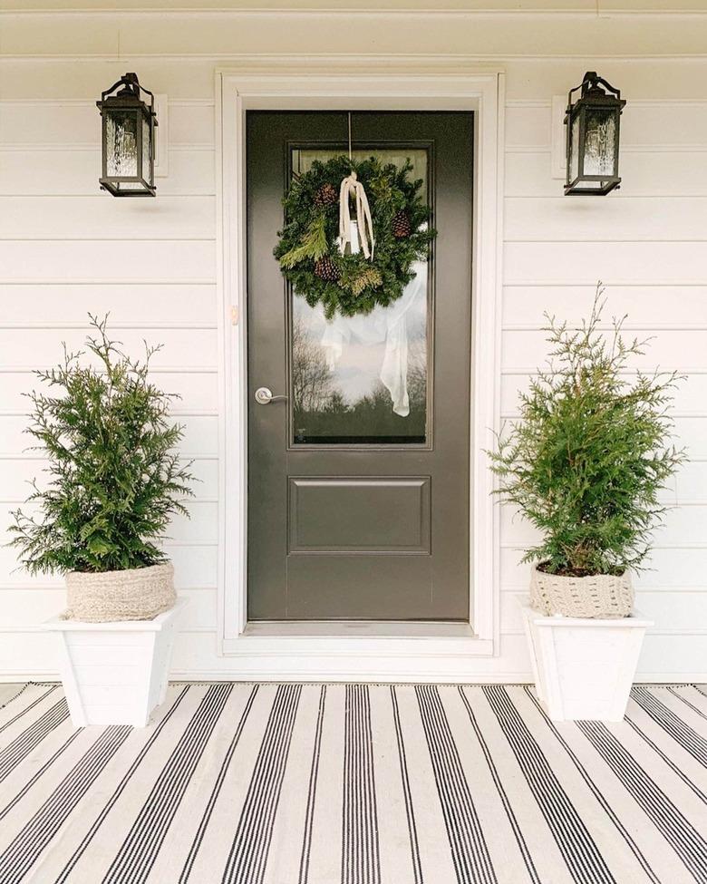 two evergreens on winter front porch