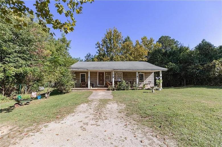 A single-story house at the end of a dirt path