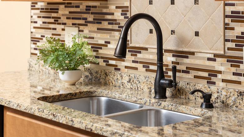 kitchen with granite counter top and busy backsplash