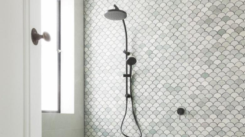 fan-shaped mosaic tile accent wall in green bathroom