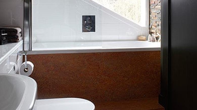 modern black bathroom with cork flooring and brick accent wall