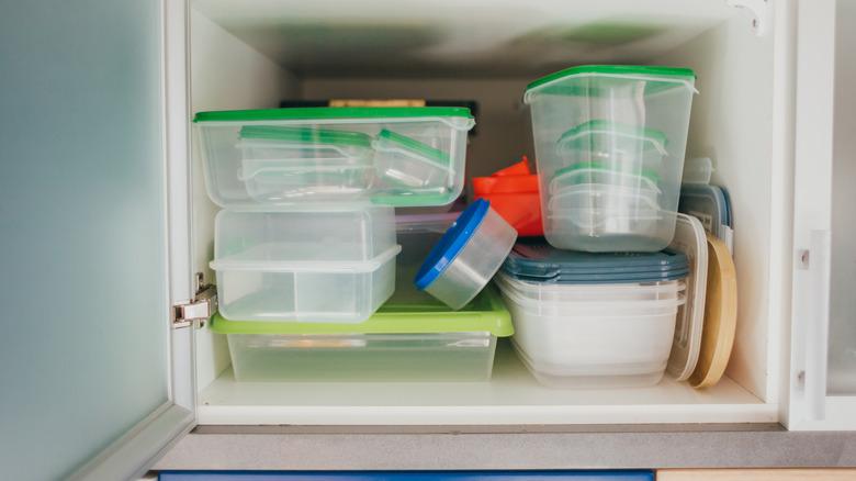 kitchen cabinet cluttered with Tupperware