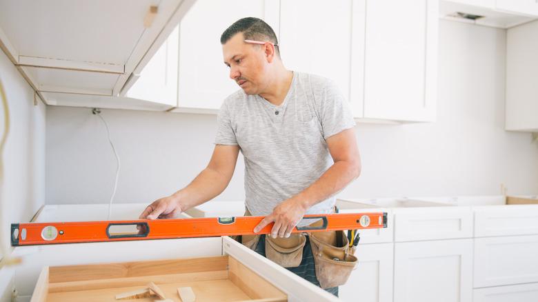 man using level on unfinished countertop