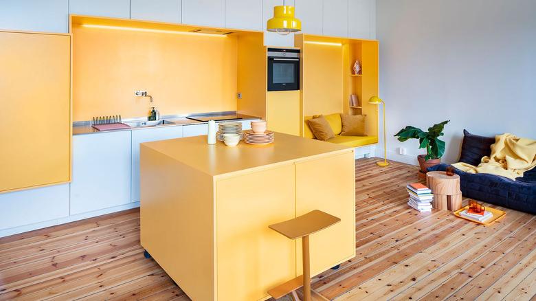 open concept yellow living room and kitchen