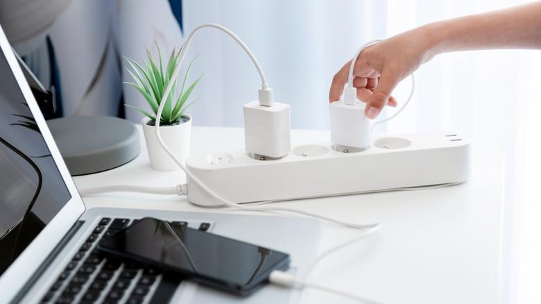 laptop and phone with wires on desk