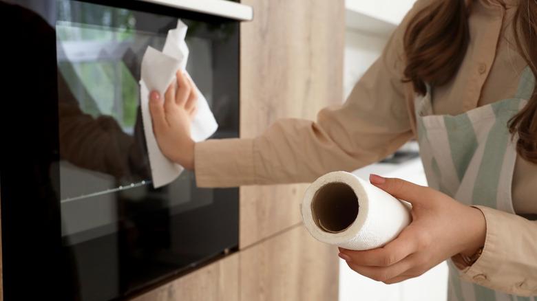 woman wiping surface with paper towel