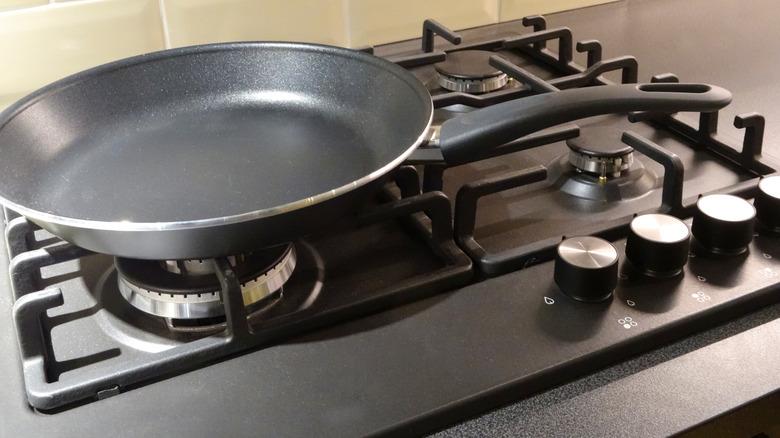 black nonstick cookware sauté pan sitting on stove eye