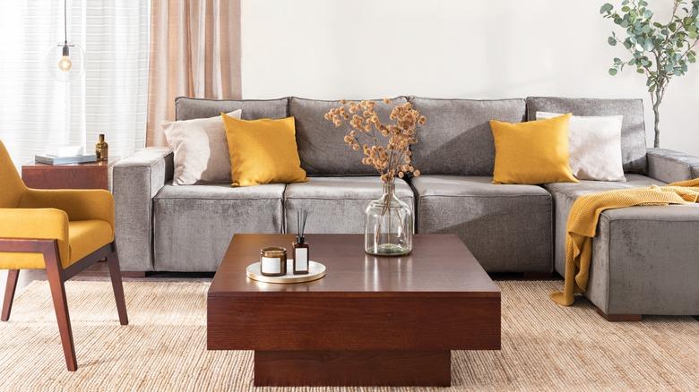 Grey sectional with yellow pillows and a chaise