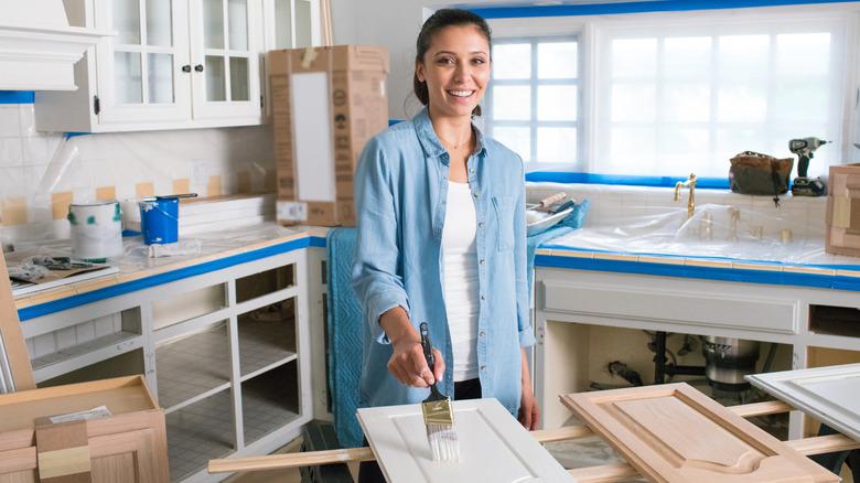 woman painting cabinet door