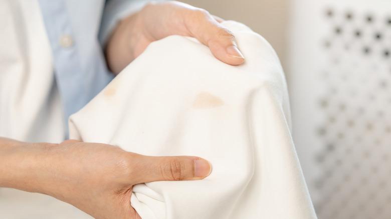 Woman holding up stained white shirt