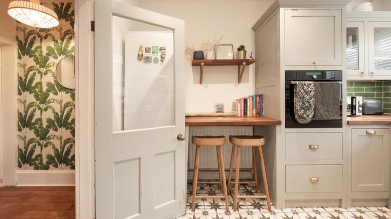 white kitchen with fun wallpaper and tiling