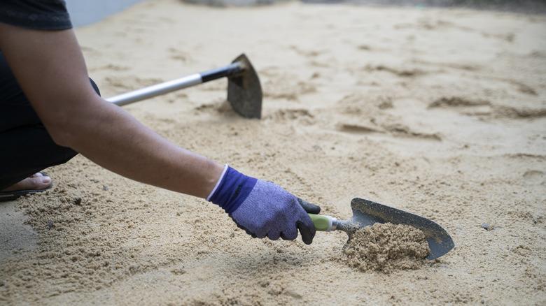 Person adding sand into yard