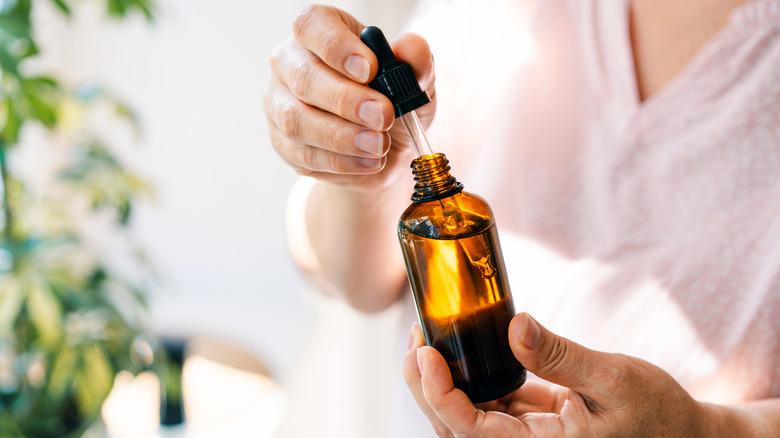 A person opening a bottle of essential oils