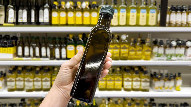 Person holding a bottle of olive oil