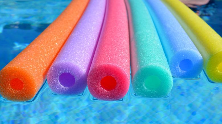 multicolored pool noodles in water