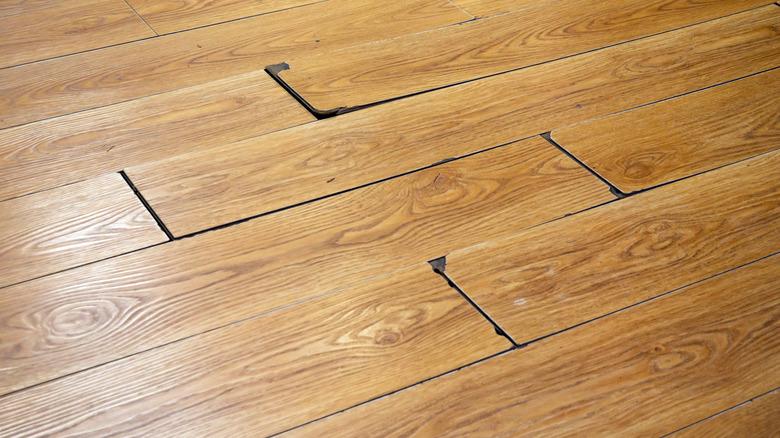 Poorly installed wood planks with gaps between several planks.