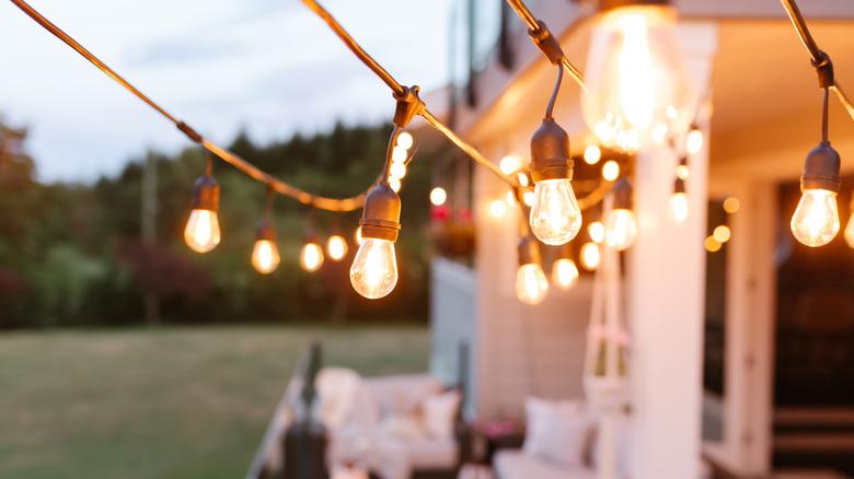 close-up of outdoor string lighting with patio blurred in background