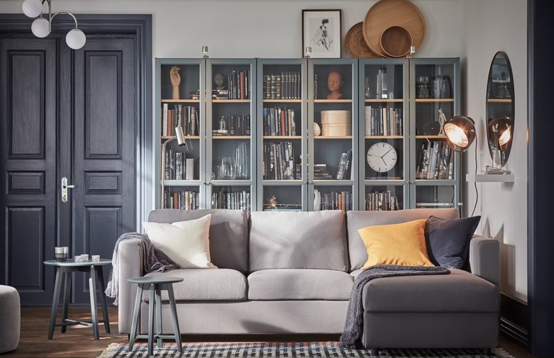 Living room with couch, pillows, rug, table, bookcases.