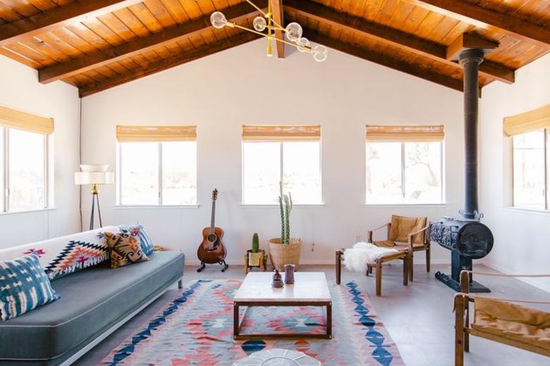 living room with wood burning stove and open beamed wood ceiling Southwestern furnishings