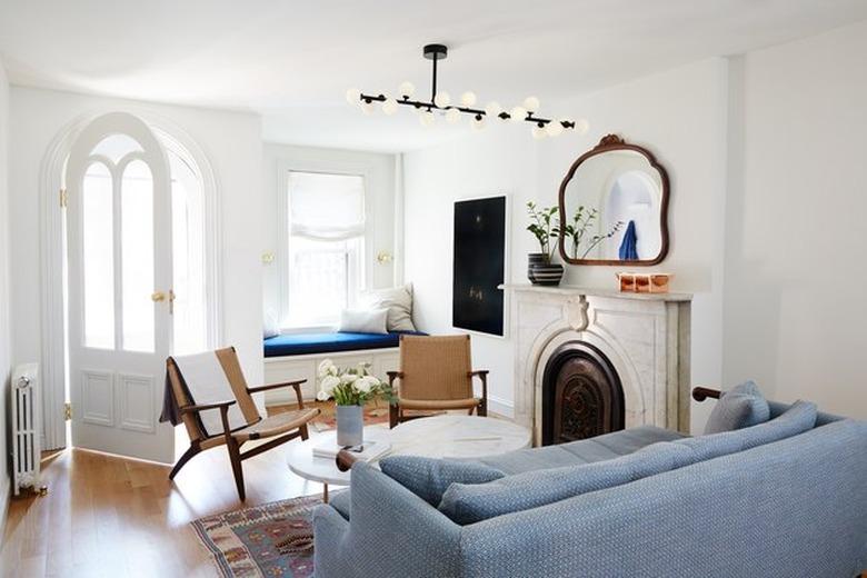 townhouse living room with modern pendant light and traditional fireplace