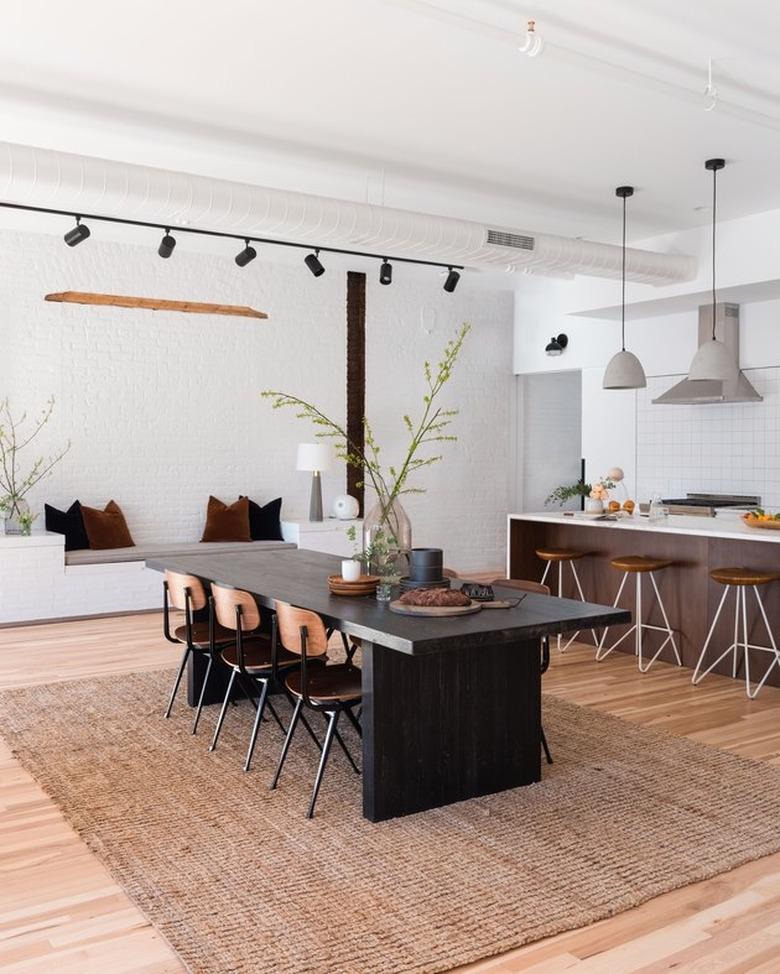 kitchen dining combination with modern track lighting and jute rug