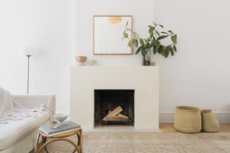 neutral living room with minimalistic fireplace and woven baskets