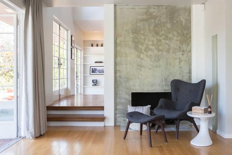 calm, luxurious entryway with minimal cement fireplace facade