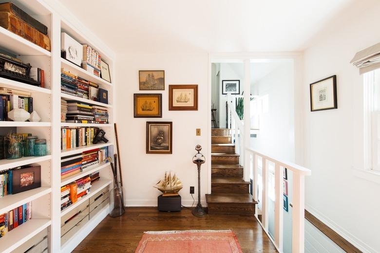 quaint cottage with bookcase library and dark wooden floors in stairway