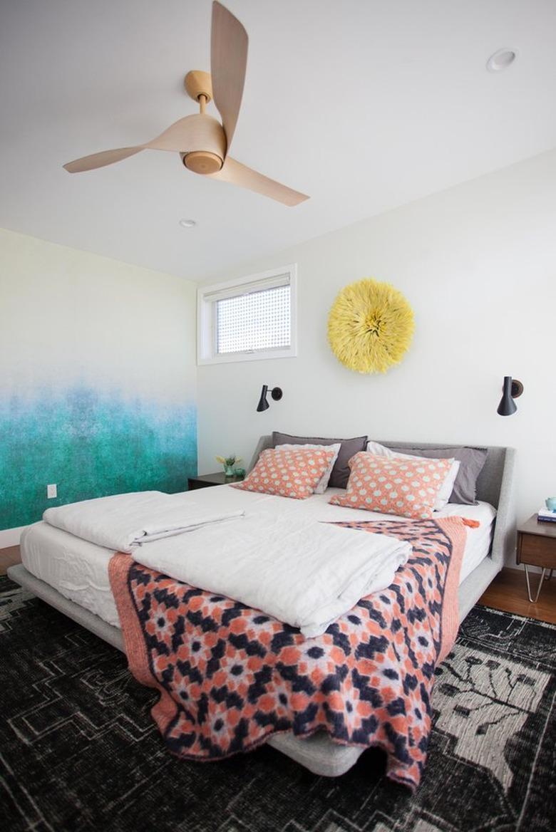 pattern-filled bedroom with modern ceiling fan and wall sconces