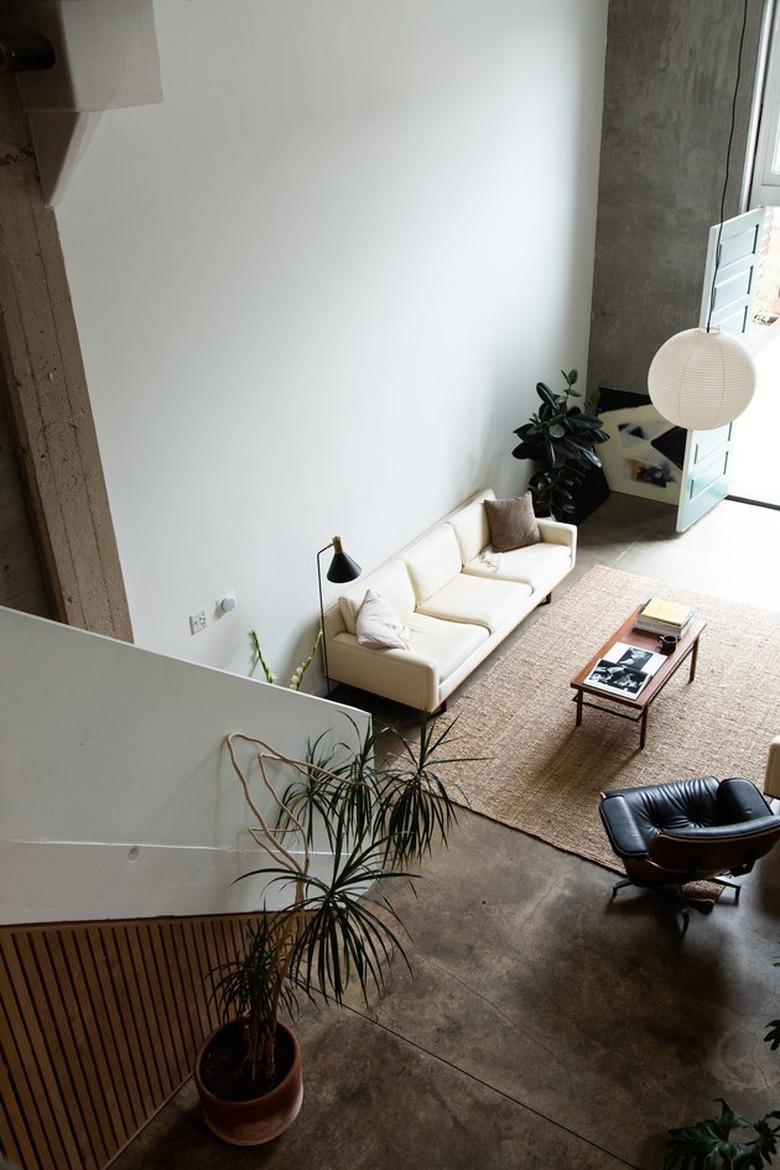 loft apartment with cement floors and hanging Noguchi lamp