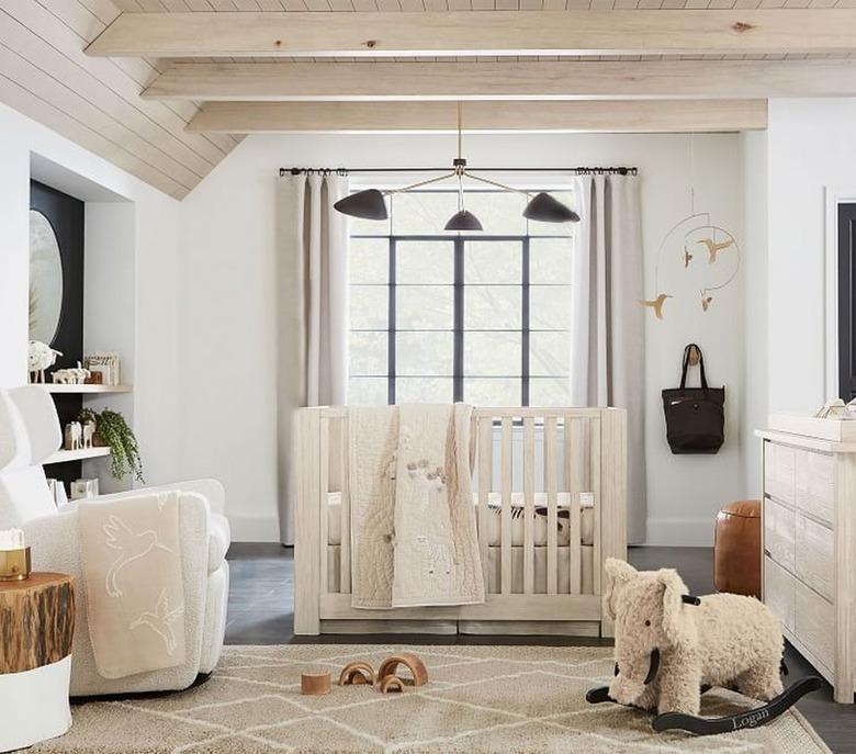 nursery space with light walls and crib and black lighting fixture