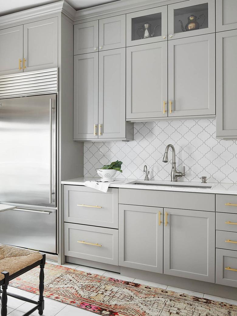 gray kitchen with white arabesque tile backsplash