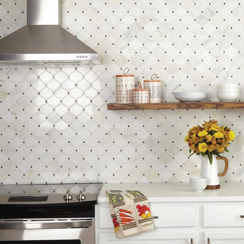 white kitchen with arabesque tile backsplash featuring black dots