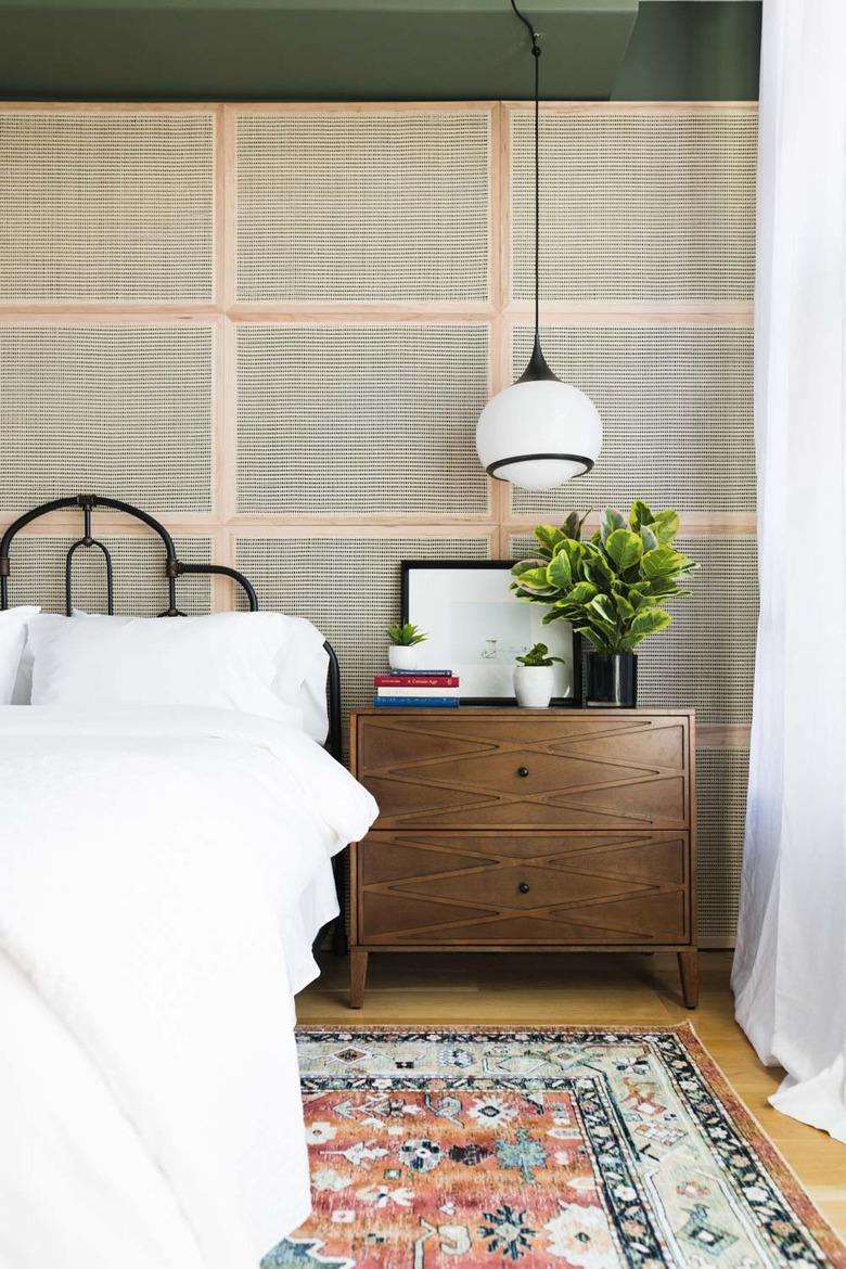 art deco bedroom with cane accent wall and hanging pendant lights