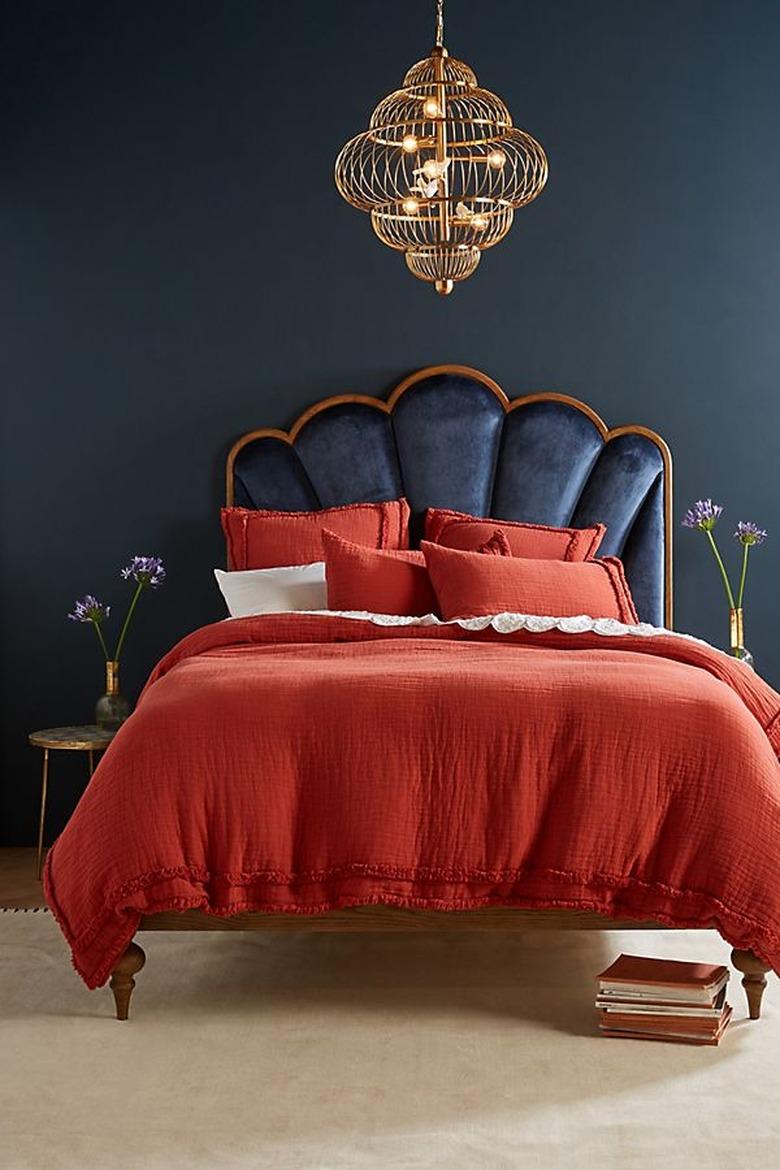 art deco furniture in anthropologie bedroom with crimson bedding