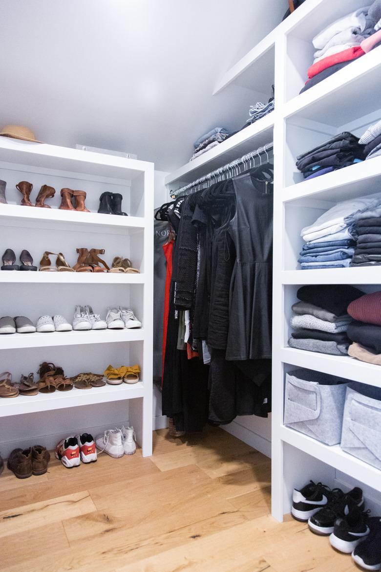 Attic Closet ideas with built-in shelving and light wood floors