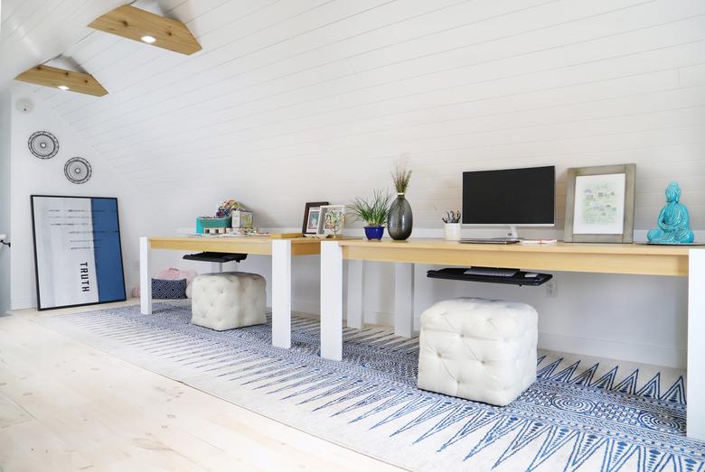 attic office idea with two desks and square poufs