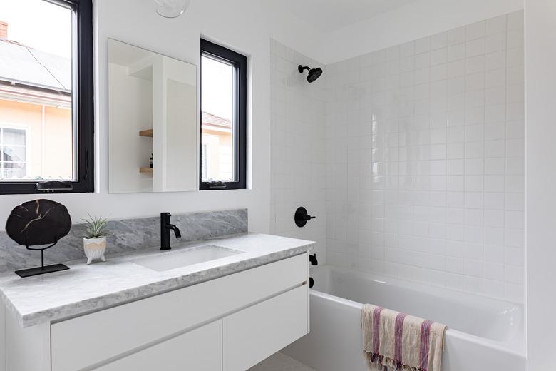 bathroom with shower/bathtub combo, bathroom vanity; grey, white and black color scheme