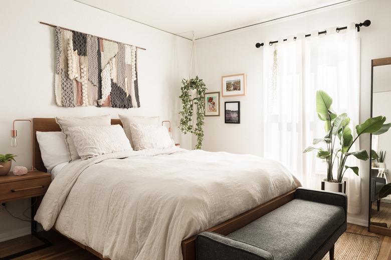 Boho bedroom with wall hanging over bed