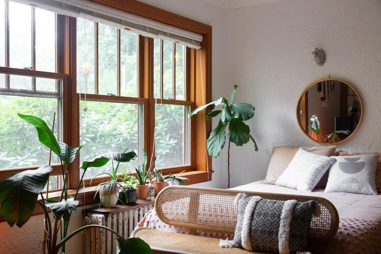 Bed with cane bench and large bedroom window