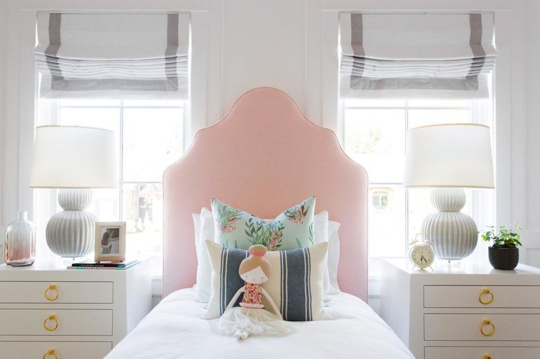 girls bedroom idea with pink upholstered headboard and matching nightstands