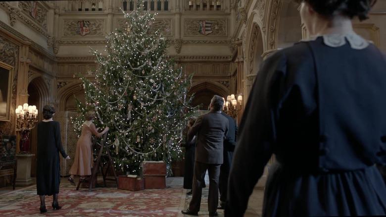 scene from Downton Abbey with figures around a Christmas tree