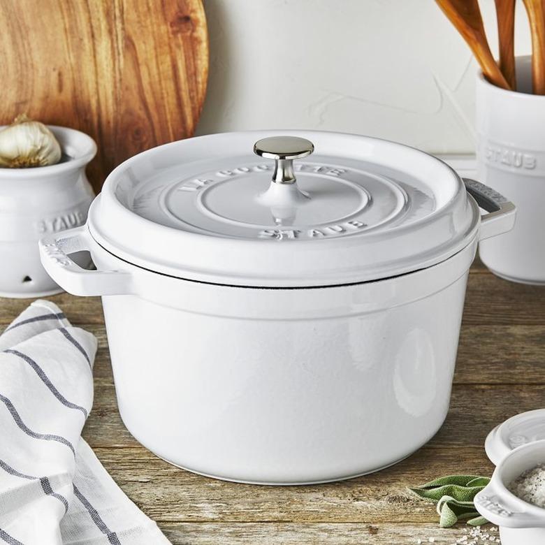 Staub white dutch oven on a countertop with other kithen items