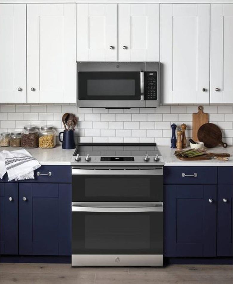 stove brand GE in a blue and white kitchen with stove and microwave