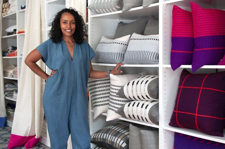 person standing near shelves of textiles