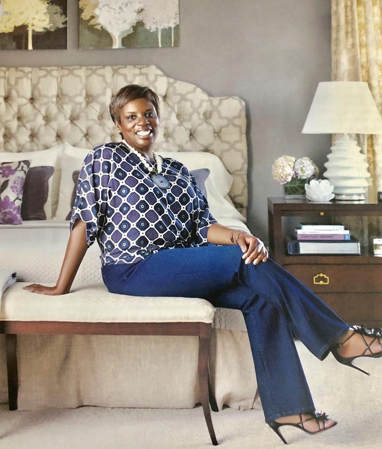 photograph of designer iantha carley sitting on chair near bed