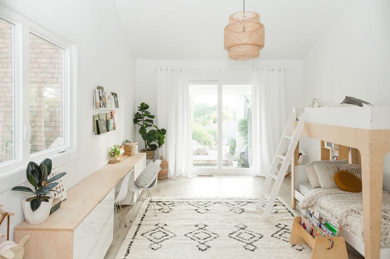 bohemian kids bedroom idea with woven pendant and patterned area rug with potted plants