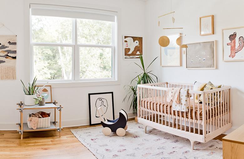 bohemian baby nursery idea with hanging mobile above crib and gallery wall