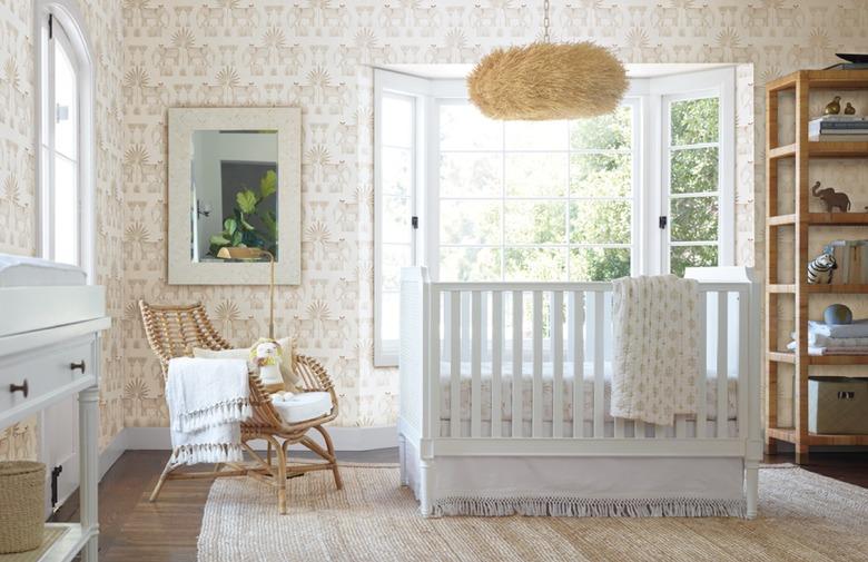 bohemian baby nursery idea with shell pendant, rattan chair, and elephant print wallpaper